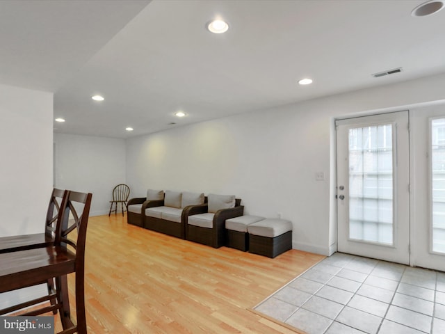 living room featuring light wood-type flooring, visible vents, baseboards, and recessed lighting