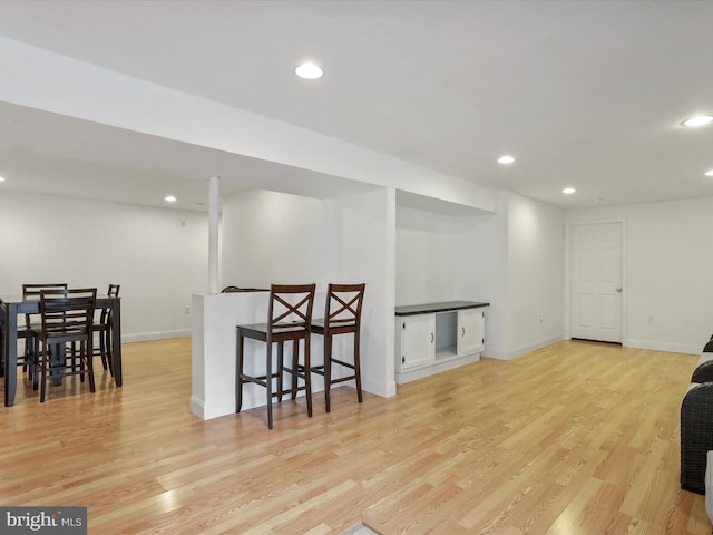 interior space featuring recessed lighting, baseboards, and light wood finished floors