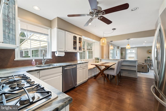 kitchen featuring stainless steel appliances, a sink, glass insert cabinets, and white cabinetry