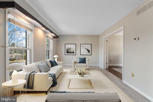 carpeted living room with baseboards and visible vents