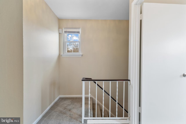 stairway with baseboards and carpet flooring