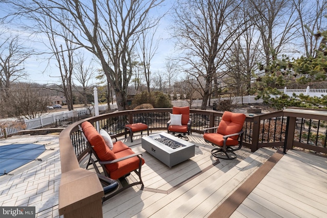 wooden terrace with an outdoor fire pit, a fenced backyard, and a fenced in pool