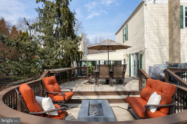 wooden terrace with outdoor dining space and an outdoor living space with a fire pit