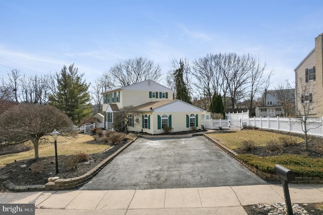 traditional-style house with fence and aphalt driveway