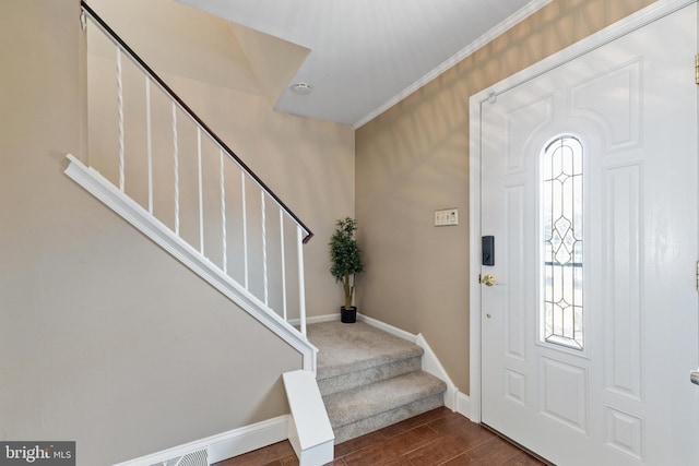 foyer entrance featuring dark wood-style flooring, a healthy amount of sunlight, stairway, and baseboards