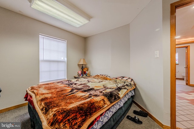 bedroom featuring light carpet and baseboards