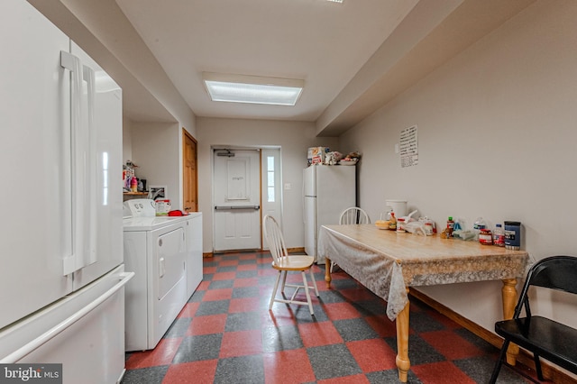 interior space with dark floors, separate washer and dryer, and freestanding refrigerator