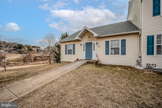 view of front of home featuring a shingled roof and a front yard