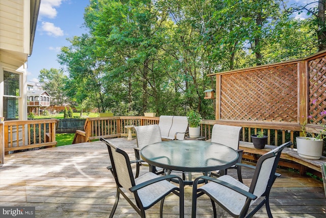 wooden terrace with outdoor dining space and fence