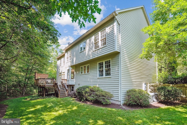 rear view of house with stairs, fence, a lawn, and a wooden deck