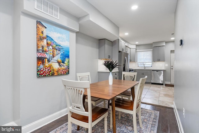 dining area with light wood-style floors, recessed lighting, visible vents, and baseboards