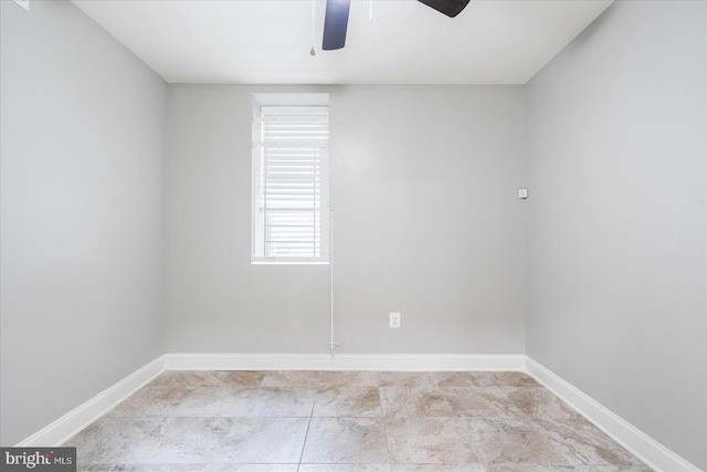 empty room featuring ceiling fan and baseboards