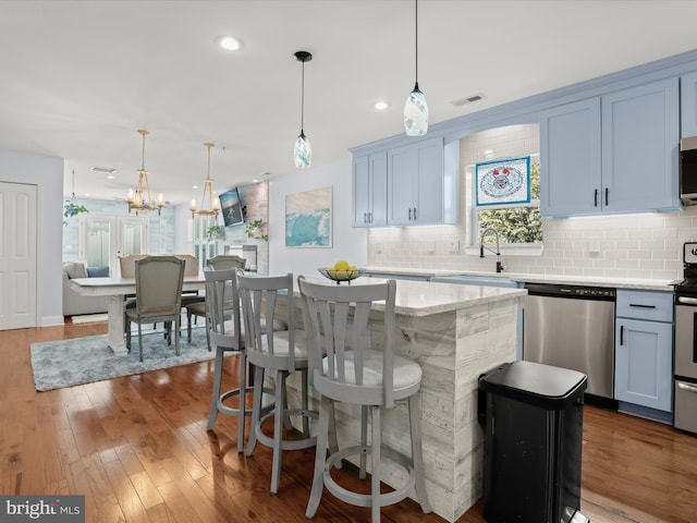 kitchen featuring a kitchen island, visible vents, dark wood-style flooring, and stainless steel appliances