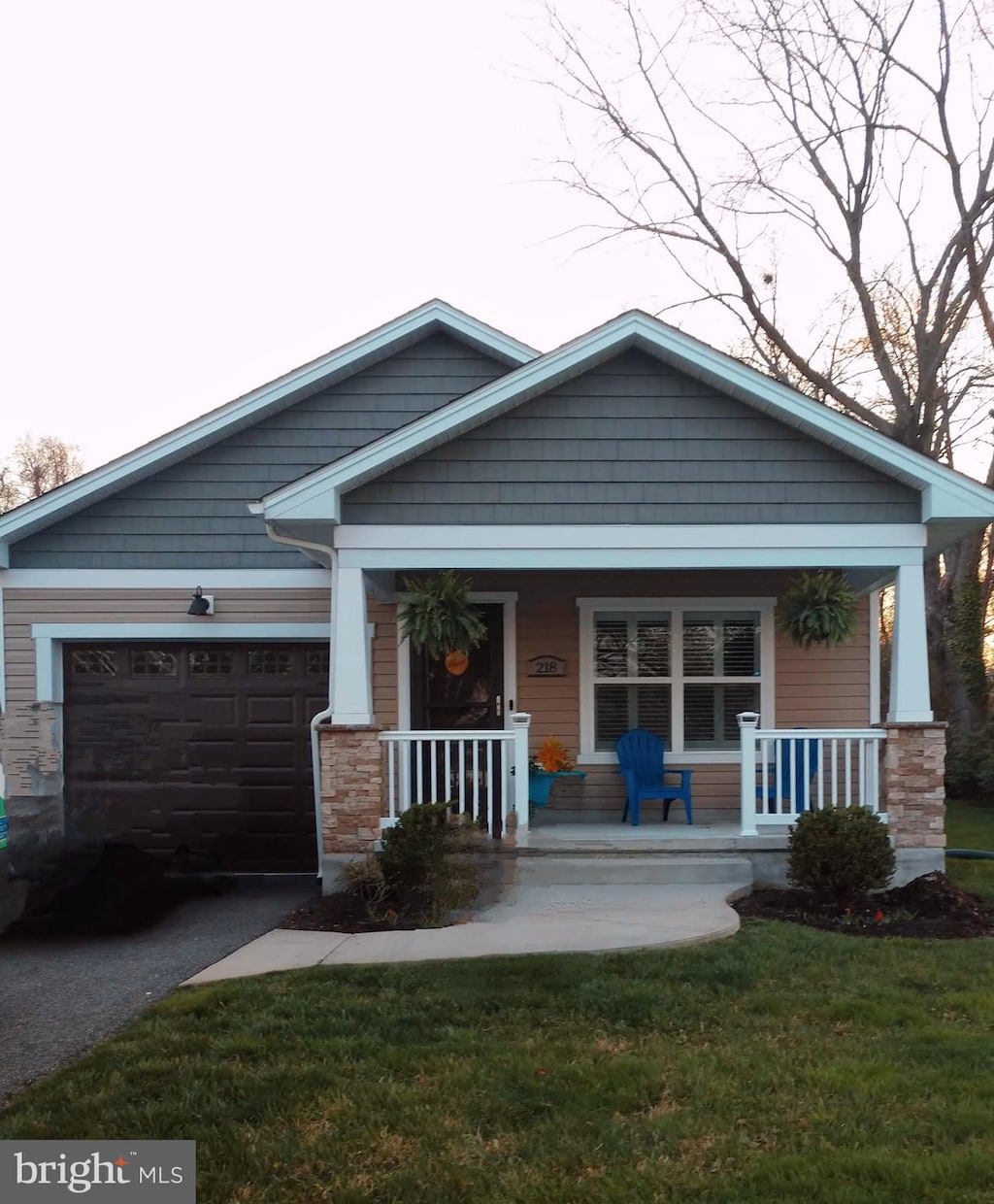 craftsman inspired home with a garage, a front yard, covered porch, and driveway