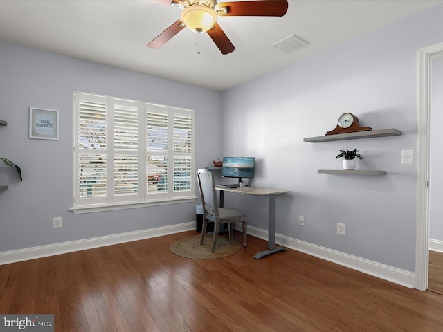 unfurnished office with visible vents, baseboards, wood finished floors, and a ceiling fan