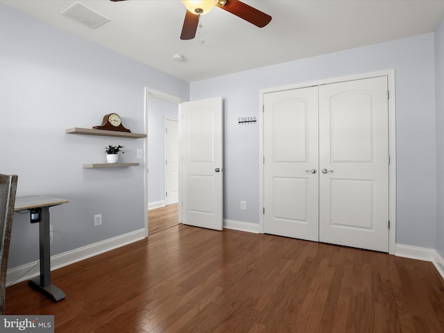 unfurnished bedroom with wood finished floors, visible vents, baseboards, ceiling fan, and a closet