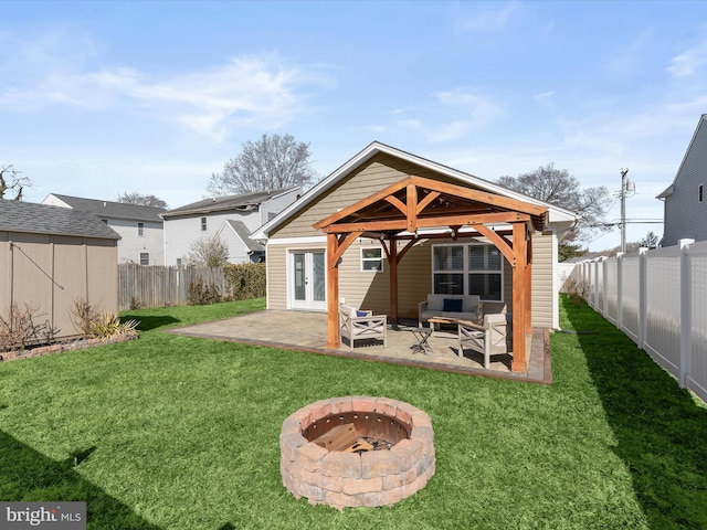 rear view of property with a lawn, french doors, a fenced backyard, a patio area, and an outbuilding
