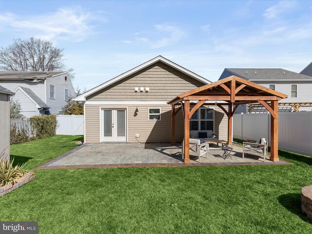 back of house featuring a gazebo, french doors, a fenced backyard, a yard, and a patio area