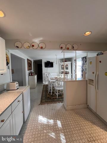 112 Mitchell St, Saint Michaels, MD 21663 - kitchen featuring white cabinets, open floor plan, freestanding refrigerator, light countertops, and light floors
