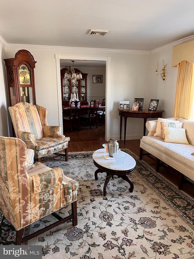 112 Mitchell St, Saint Michaels, MD 21663 - living room featuring a notable chandelier, wood finished floors, visible vents, and crown molding