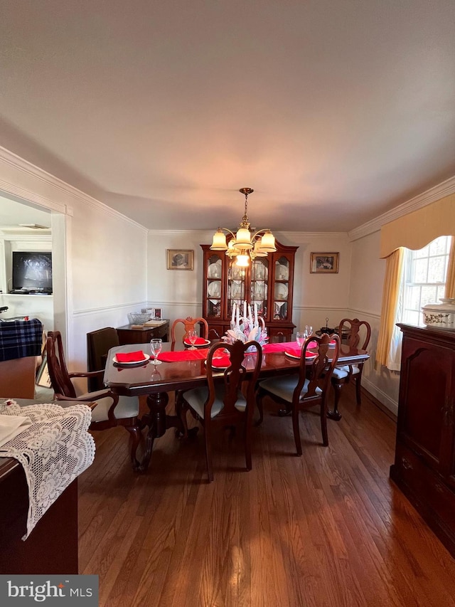 112 Mitchell St, Saint Michaels, MD 21663 - dining room featuring dark wood-type flooring, a wainscoted wall, crown molding, and an inviting chandelier