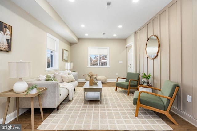 living area with light wood-style flooring, visible vents, baseboards, and recessed lighting