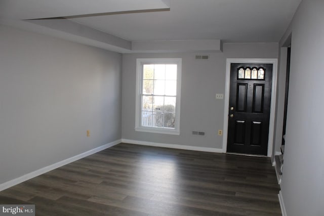 foyer with dark wood-type flooring, visible vents, and baseboards