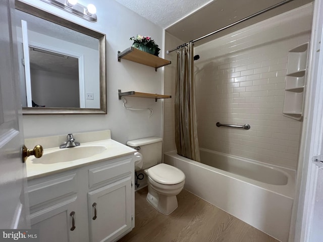 bathroom featuring toilet, wood finished floors, shower / tub combo with curtain, a textured ceiling, and vanity