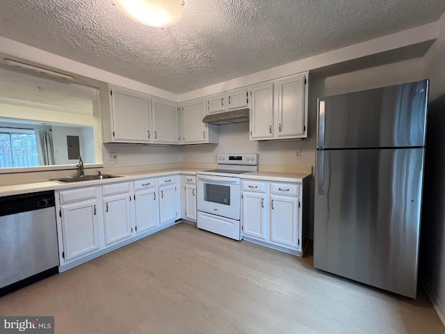 kitchen with under cabinet range hood, stainless steel appliances, a sink, white cabinets, and light countertops