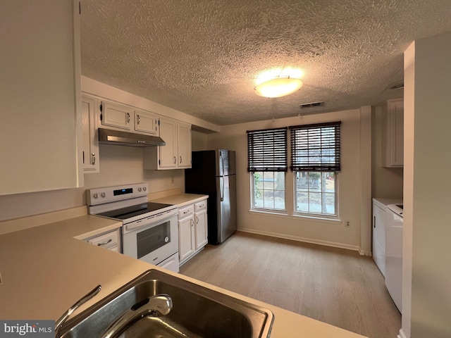 kitchen featuring white range with electric stovetop, white cabinets, washing machine and clothes dryer, light countertops, and under cabinet range hood