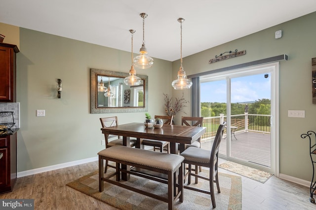 dining area featuring light wood finished floors and baseboards