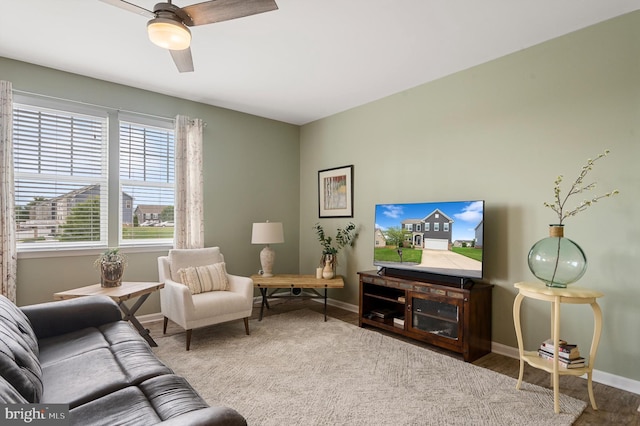 living room with ceiling fan and baseboards