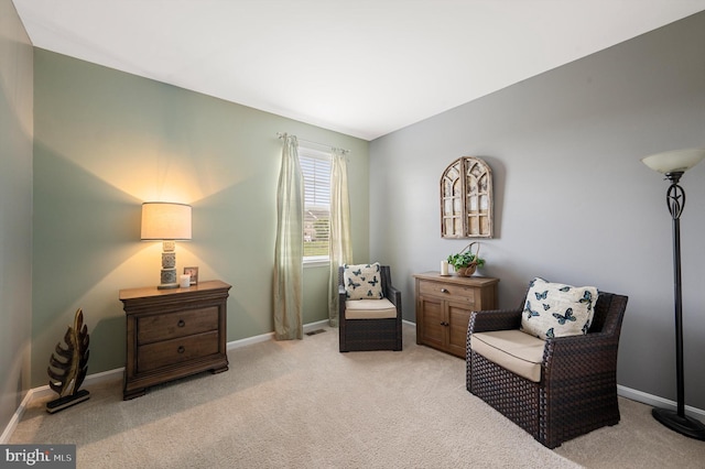 sitting room featuring light carpet and baseboards