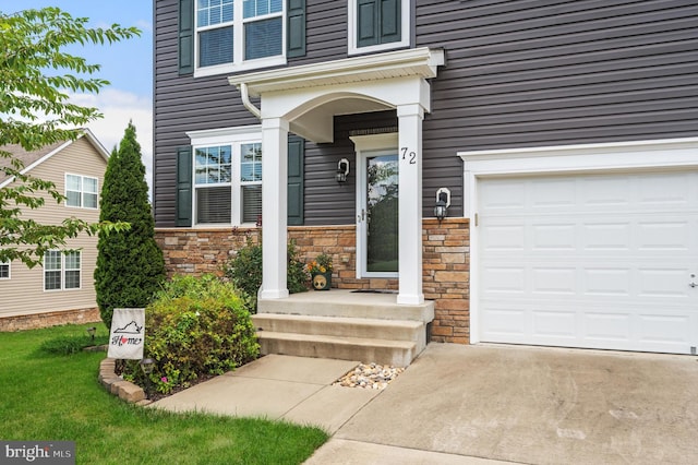 entrance to property with a garage and stone siding