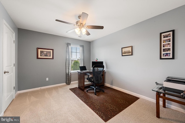 carpeted office with ceiling fan and baseboards