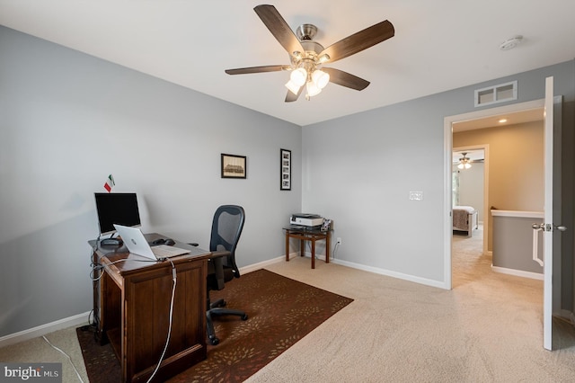 carpeted office with baseboards, visible vents, and ceiling fan