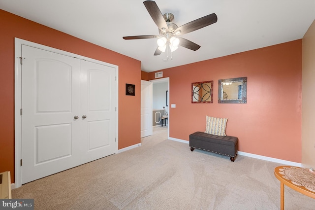 living area with carpet, visible vents, baseboards, and a ceiling fan