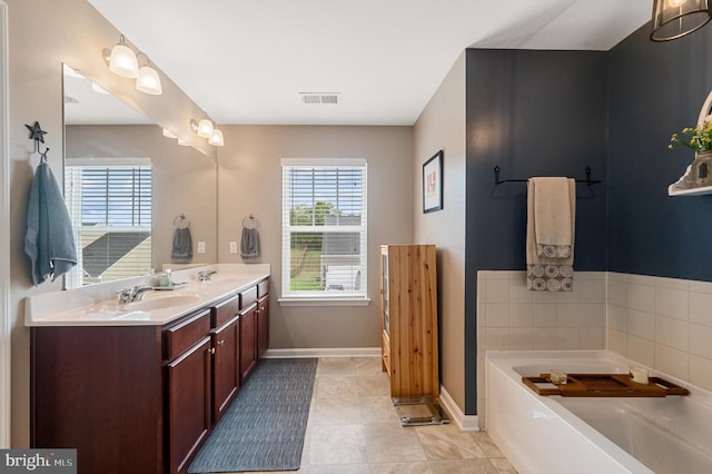 full bathroom featuring visible vents, double vanity, a sink, and a bath