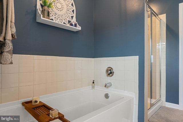 bathroom with a stall shower and a bath