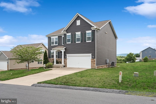 traditional home featuring central AC unit, a garage, driveway, stone siding, and a front yard