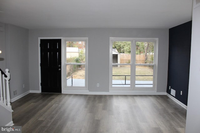 entryway with dark wood-style floors, visible vents, stairs, and baseboards