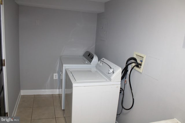 laundry area with light tile patterned flooring, laundry area, baseboards, independent washer and dryer, and electric panel