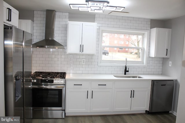 kitchen featuring wall chimney exhaust hood, appliances with stainless steel finishes, a sink, and light countertops