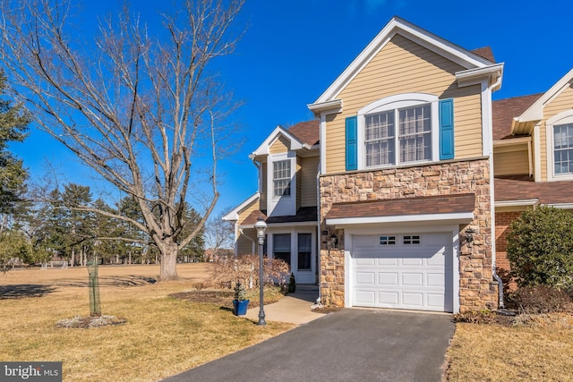 traditional-style home featuring a garage, stone siding, aphalt driveway, and a front lawn