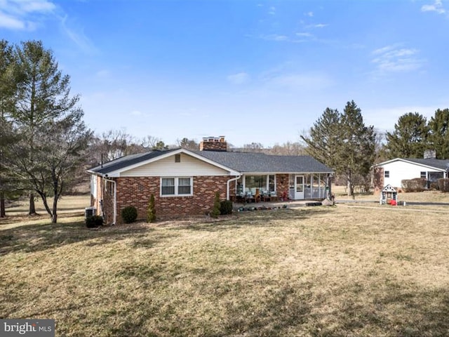 ranch-style home with a porch, a chimney, a front lawn, and brick siding