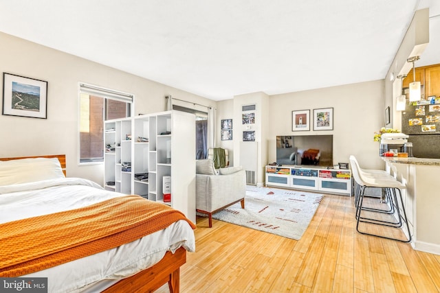 bedroom with baseboards and hardwood / wood-style floors