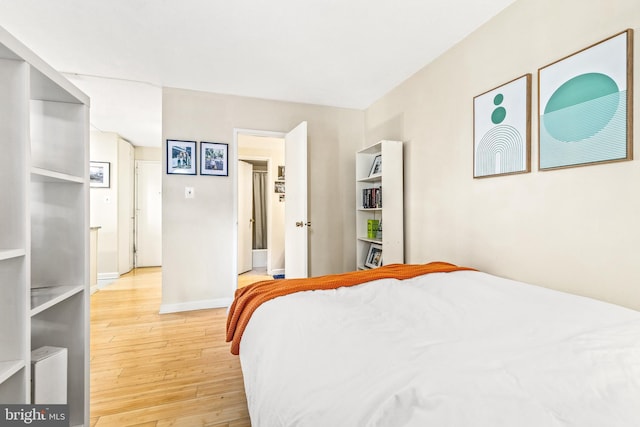 bedroom with light wood finished floors and baseboards