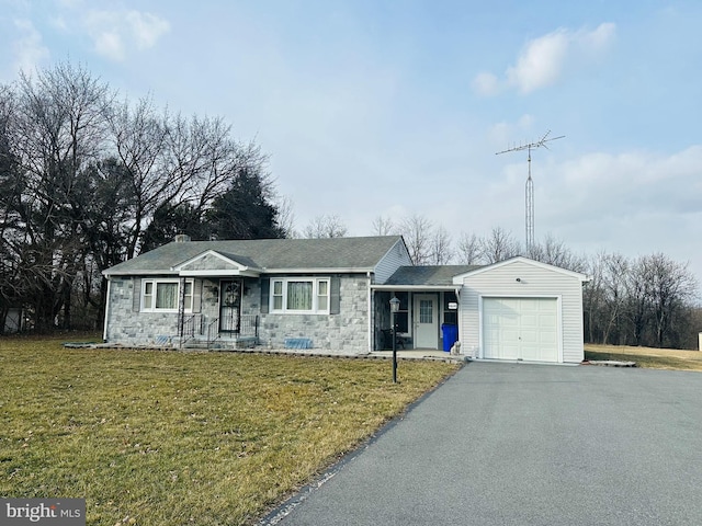 ranch-style house featuring a garage, stone siding, driveway, and a front lawn