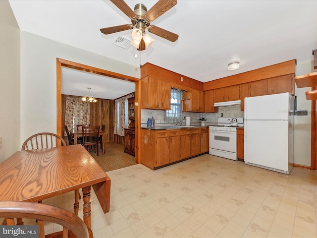 kitchen with white appliances, visible vents, brown cabinetry, decorative backsplash, and under cabinet range hood