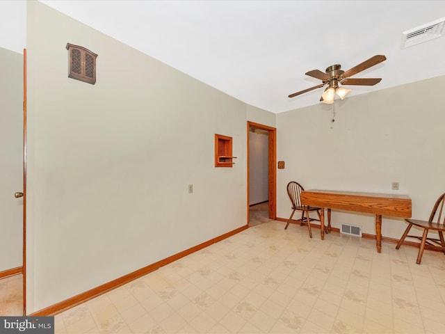 office featuring ceiling fan, light floors, visible vents, and baseboards